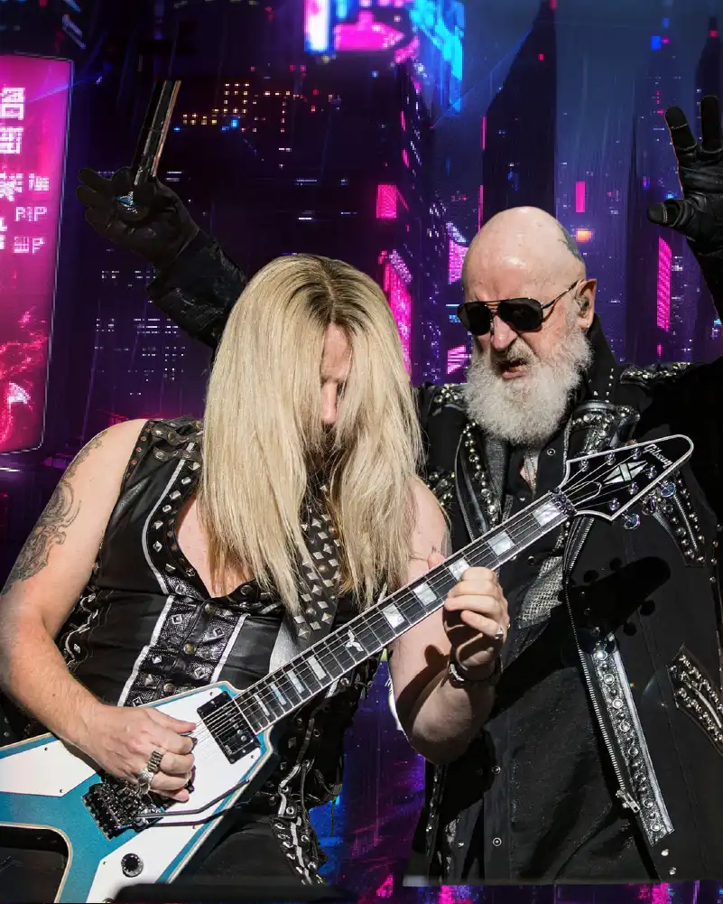 Richie Faulkner playing guitar beside Rob Halford during a Judas Priest concert